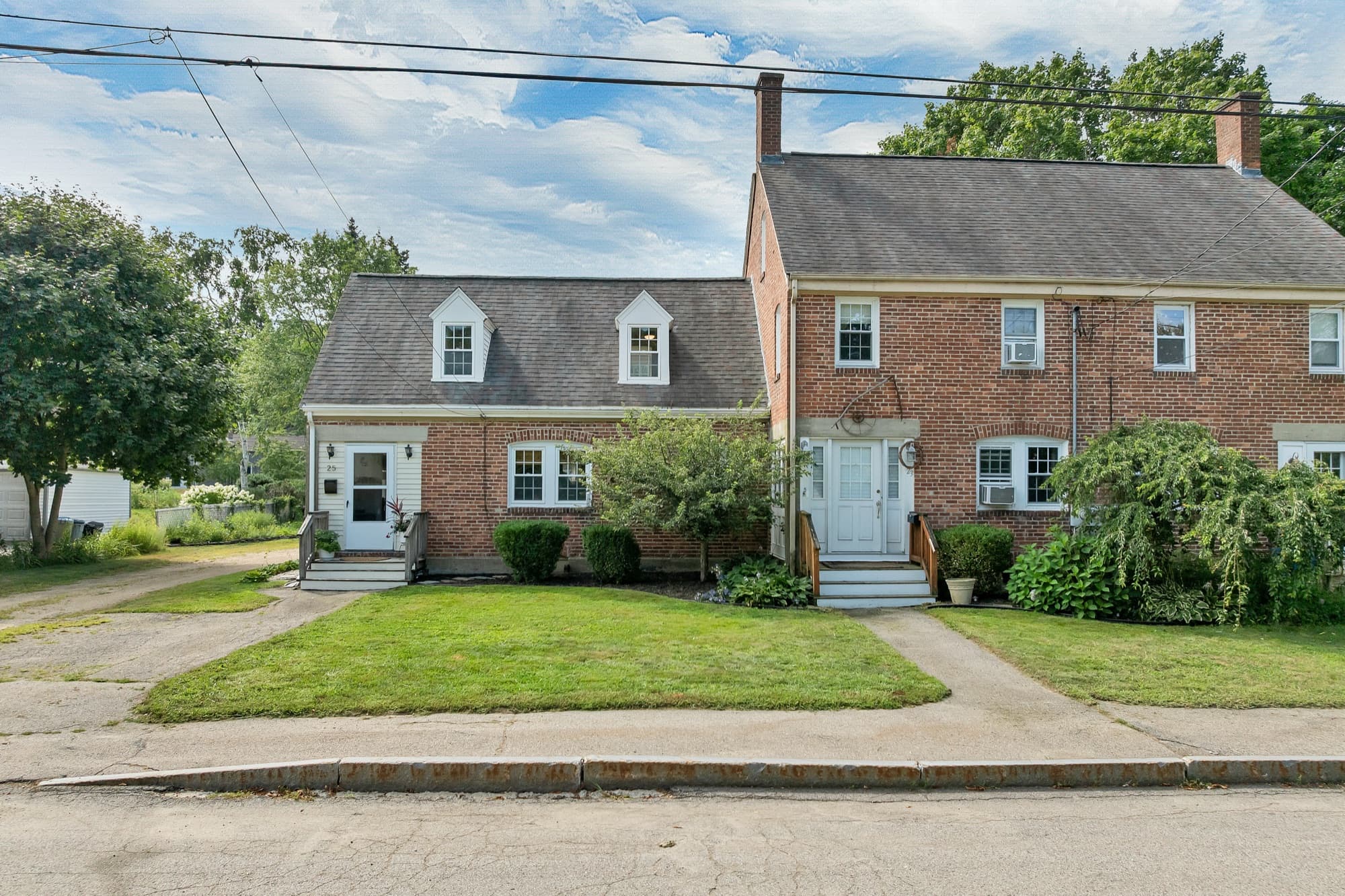 Front elevation straight on, brick with white dormers and separate entry stairs
