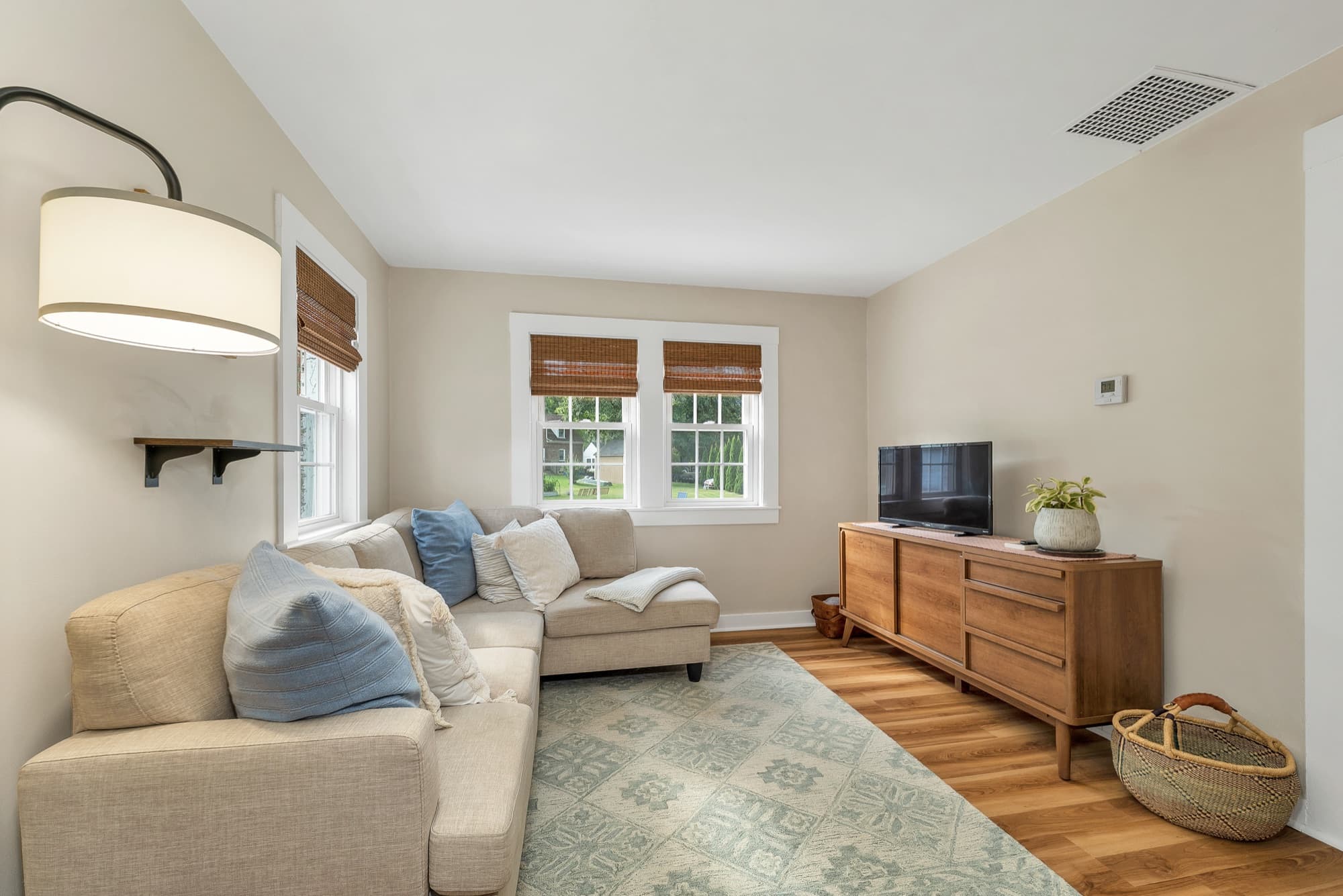 Unit 25 living room with a sectional, wood console, and wood-look flooring