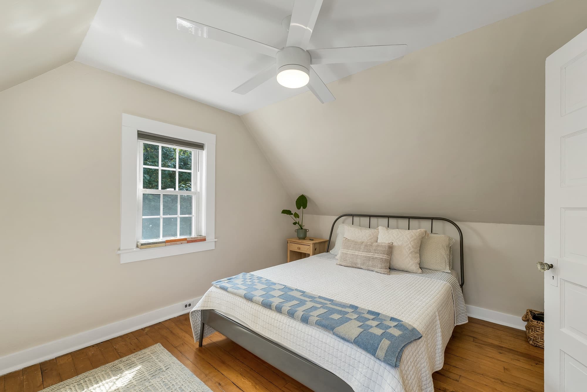 Unit 25 upstairs bedroom under the eaves, with a ceiling fan and dormer window