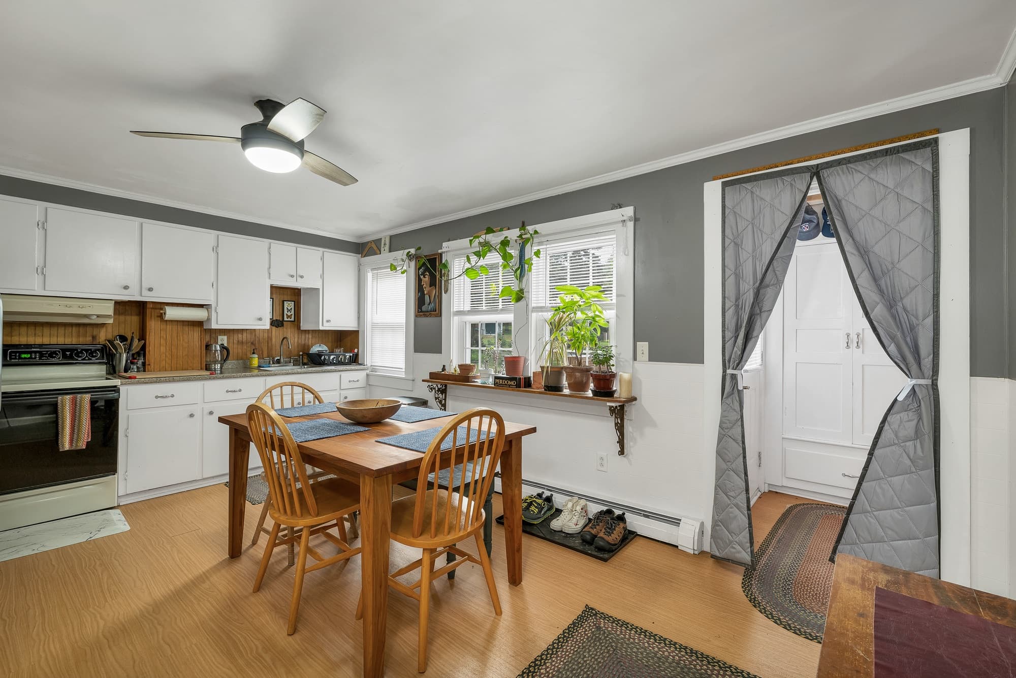 Unit 23 eat-in kitchen with white cabinets and a wood dining table