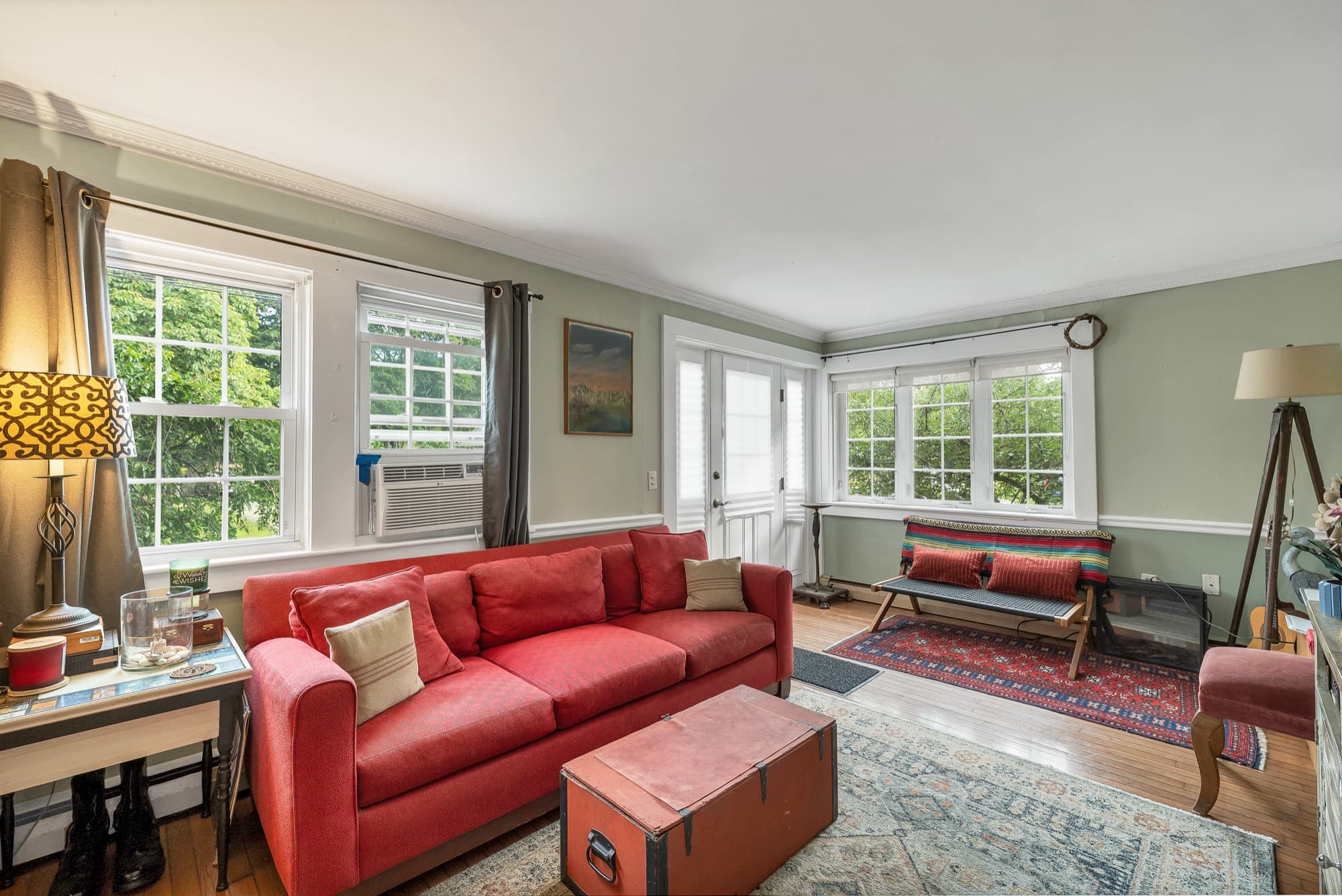 Unit 23 living room with sofas and a bank of windows