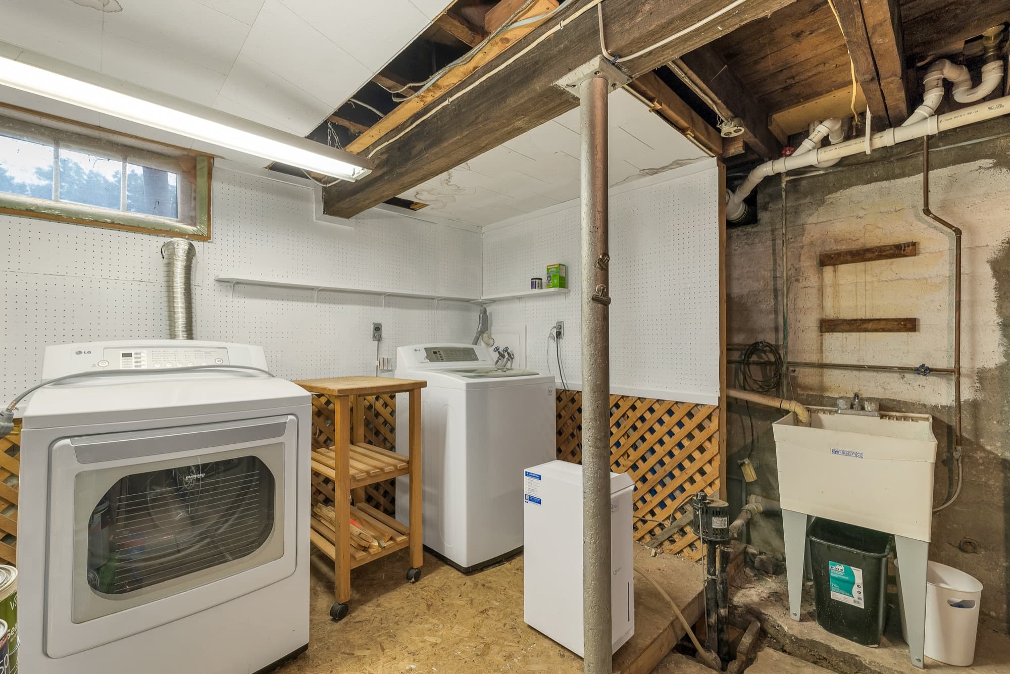 Basement laundry with washer, dryer, and utility sink